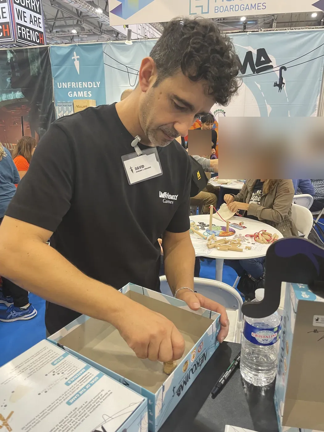 David Carmona signeert een doos Nekojima bij de stand van Unfriendly Games