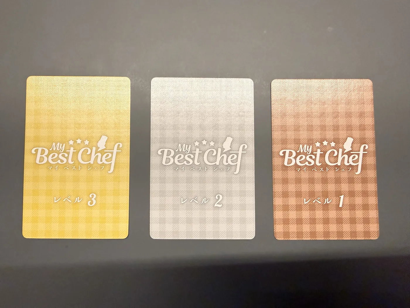 Drie kaartruggen van My Best Chef: goud niveau 3, zilver niveau 2 en brons niveau 1
